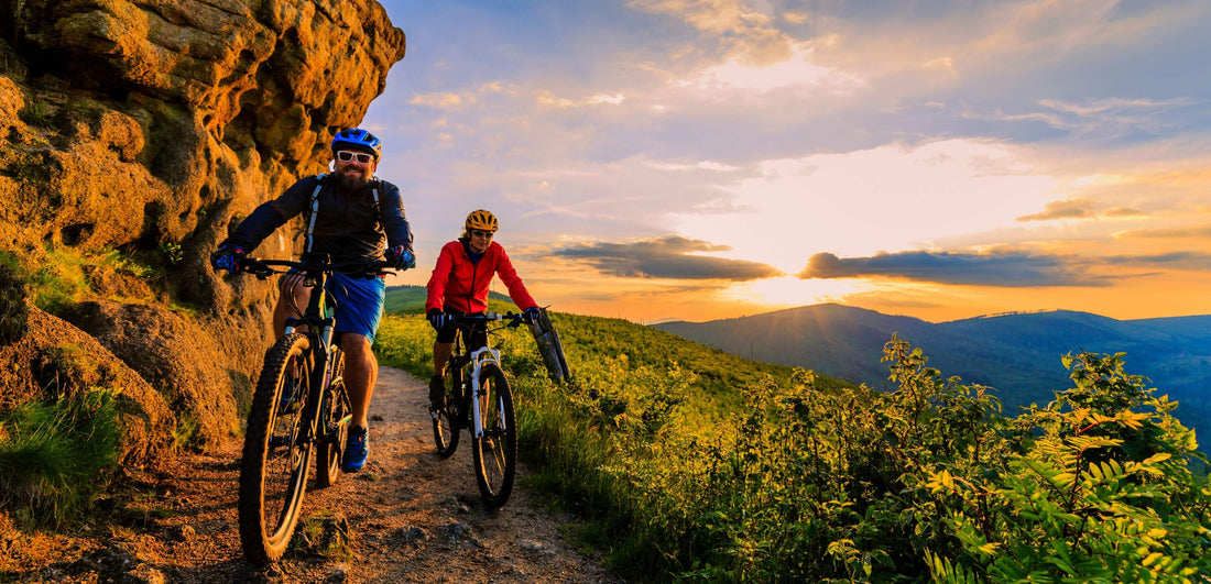 Two cyclists on a mountain trail with a scenic sunset view then return to use athlete recovery nutrition