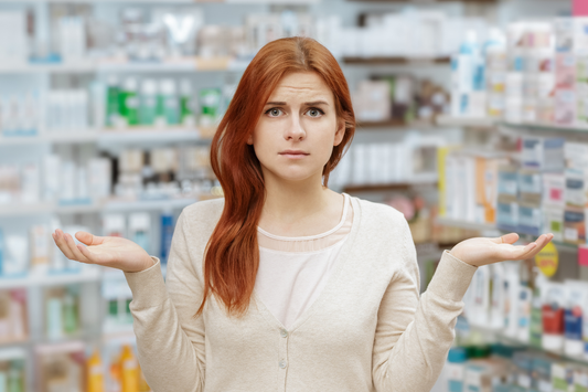 woman shrugging her shoulders as if she is confused by all of the medications around her.