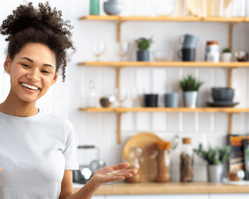 woman holding a vitamin getting ready to take it/ 