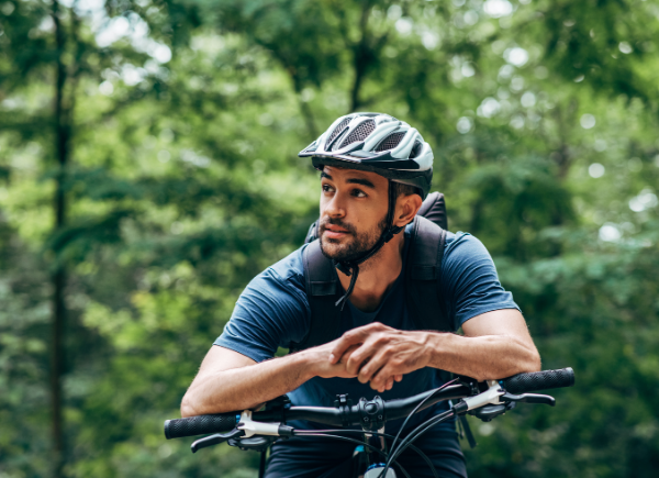 Man sitting on bike wearing a helmet to protect his brain