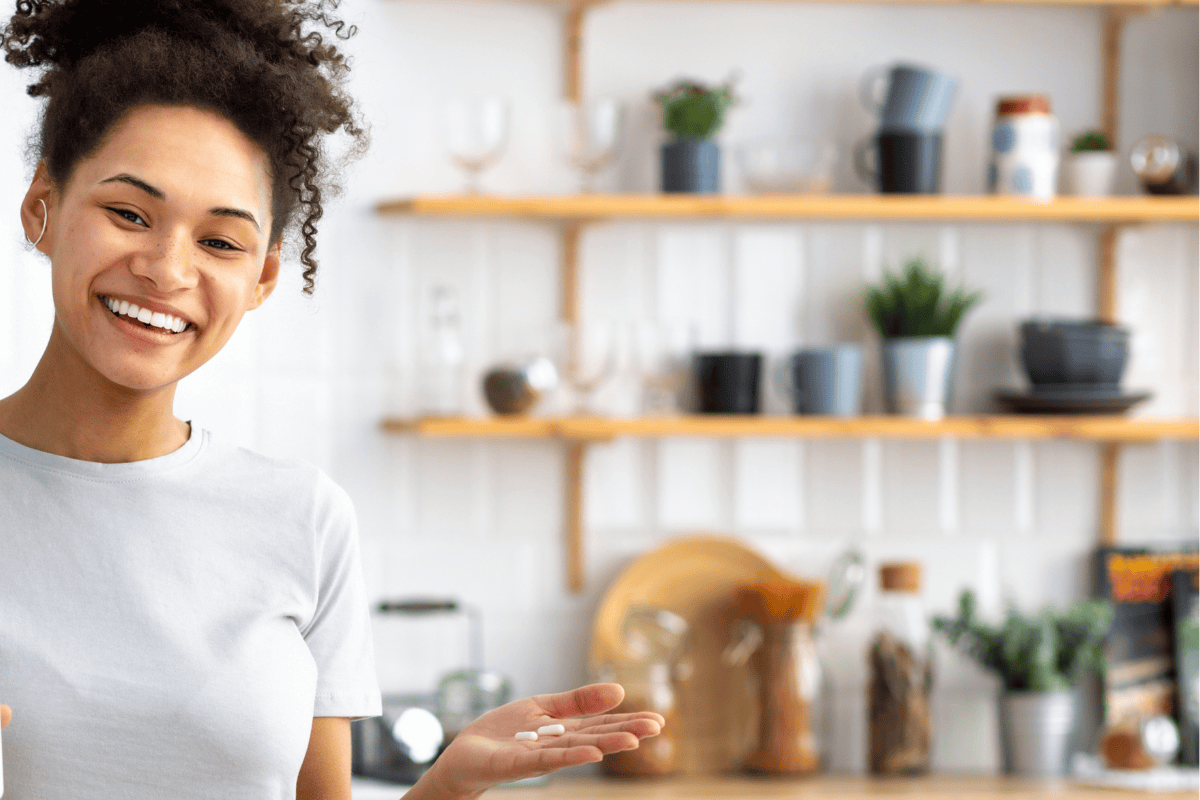 young woman holding out her daily vitamins preparing to take them. 